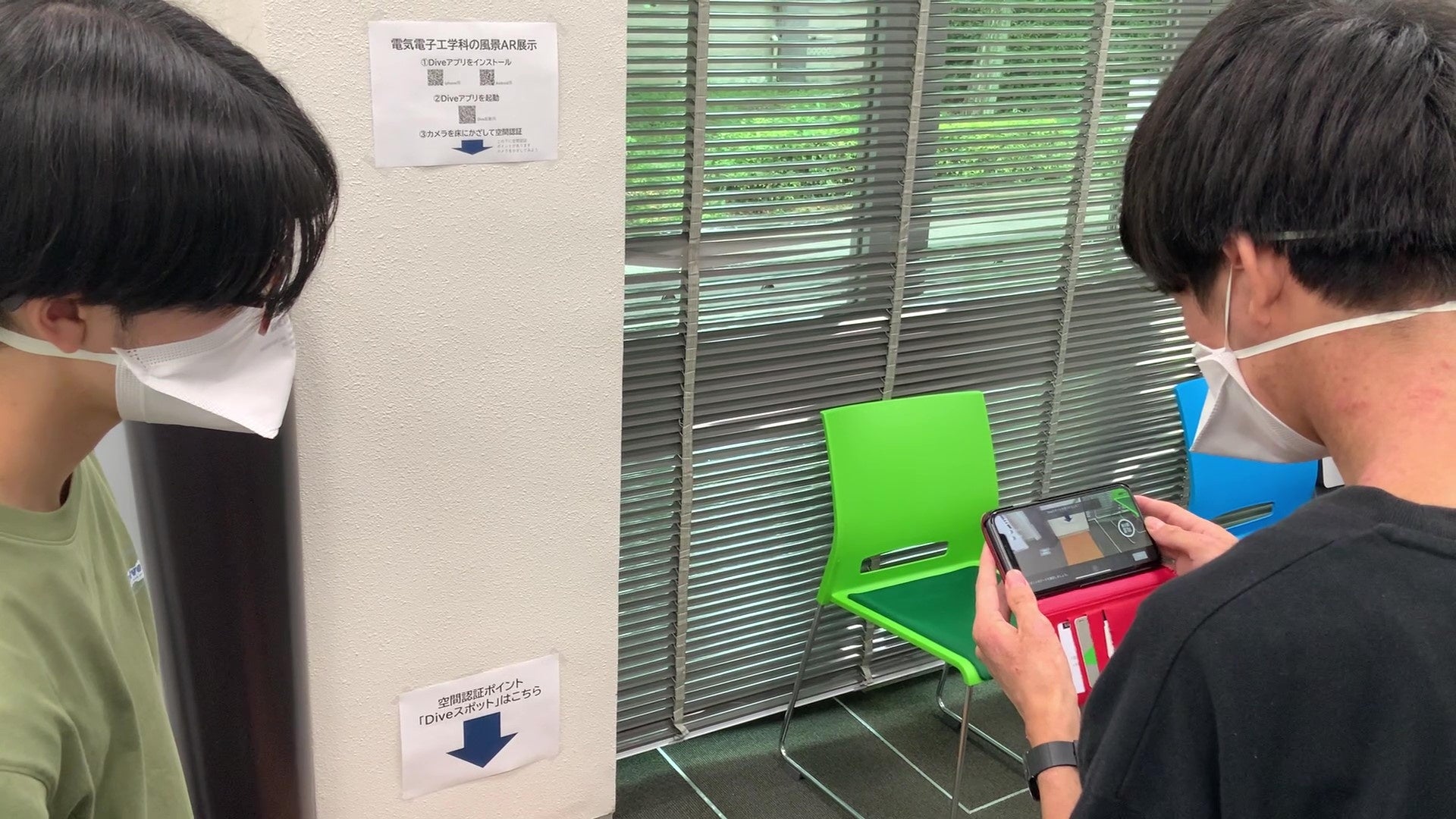 部屋に張られたDiveスポットのQRコードを読み取っている来場者