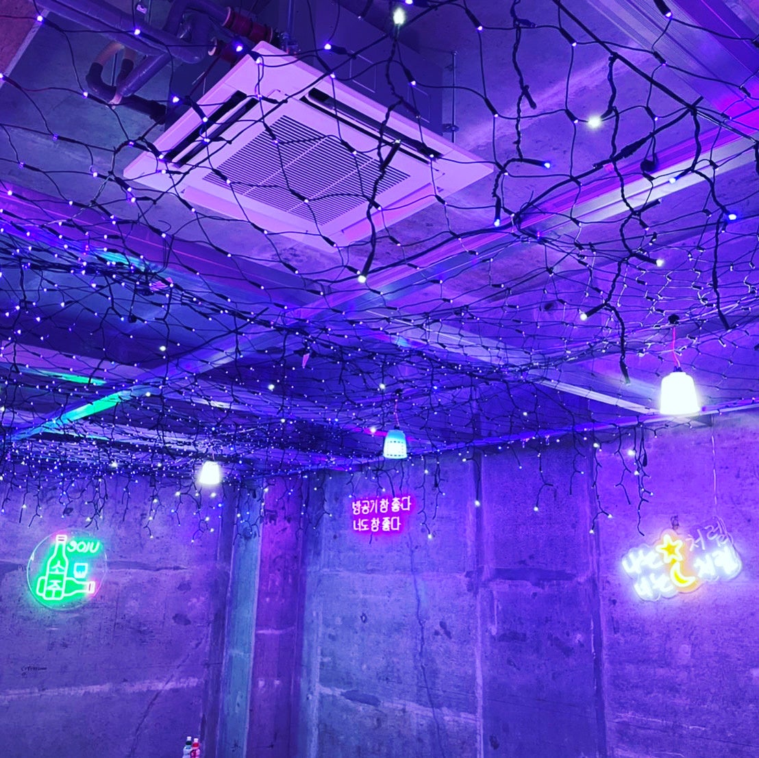 天井一面に紫のネオン。テーブルの天板には天井からのネオンが映ります