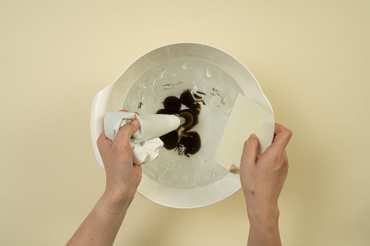 練ったわらび餅を絞り袋を使い氷水に絞り出し冷やす