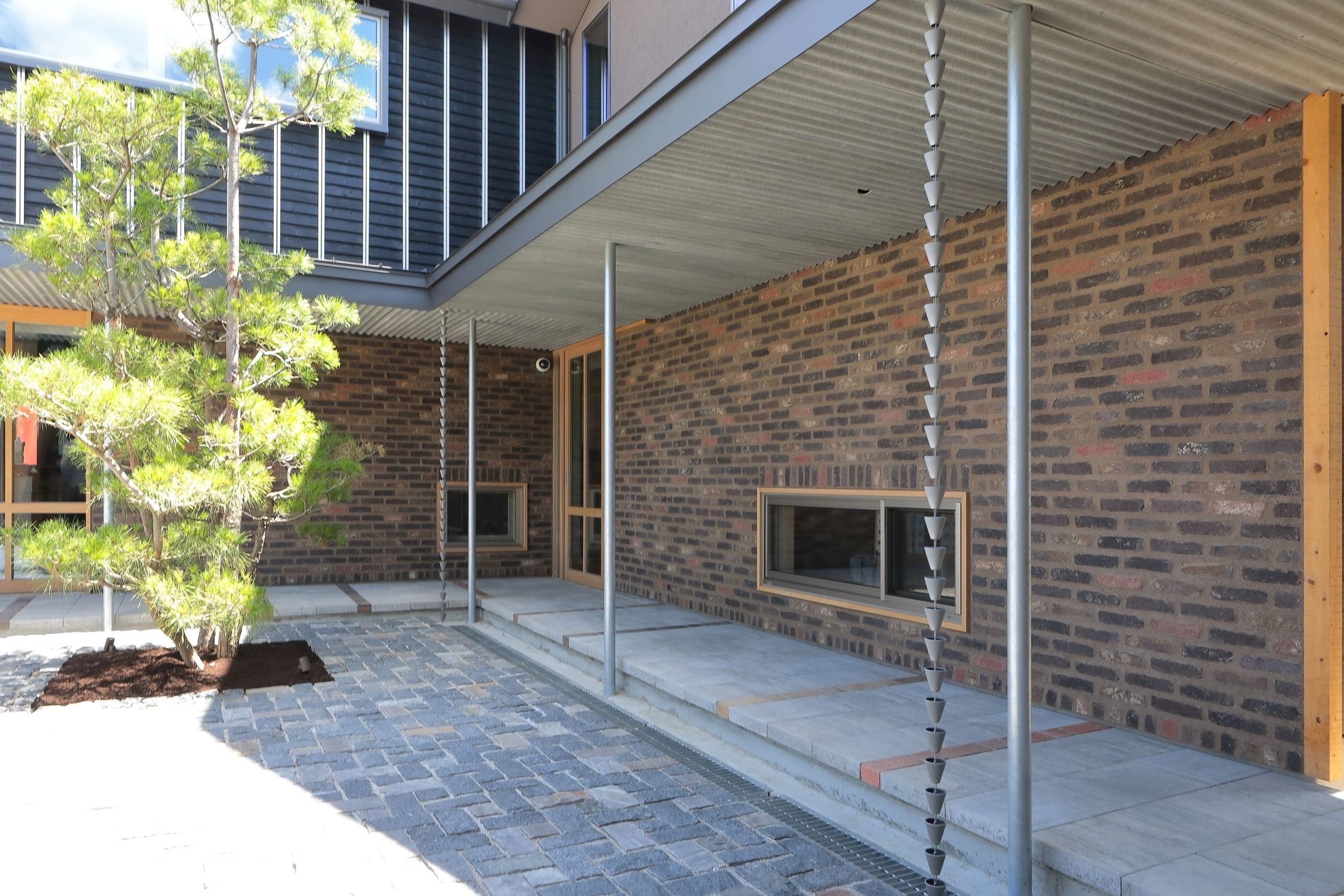 天然石を敷き詰めた、事務所棟とコミュニティスペース棟をつなぐ中庭