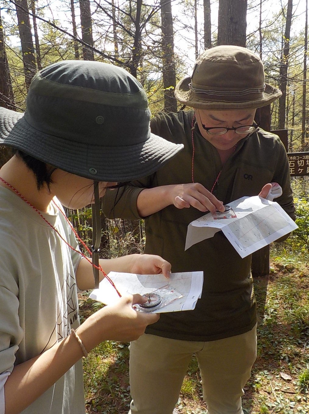 コンパスと地形図を基にルートを探す「信州アウトドア研修」の受講者＝21年10月、松本市郊外の美ケ原