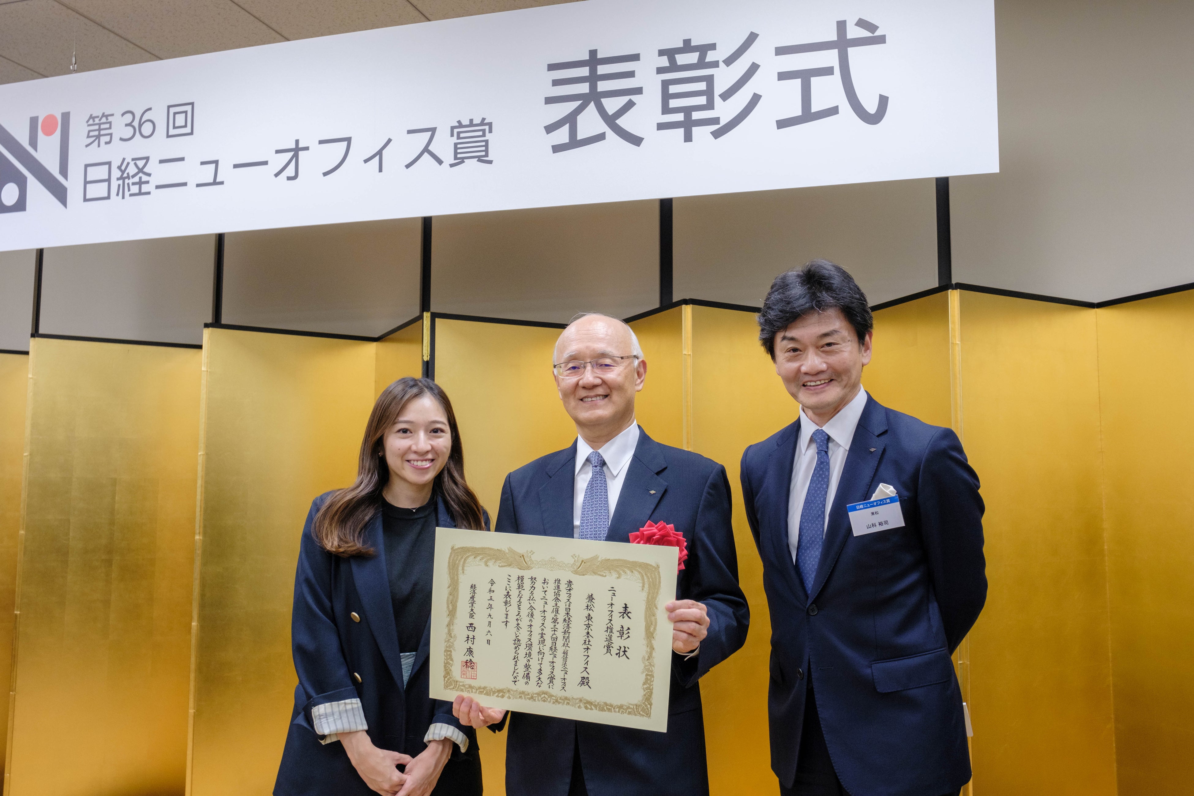 2023年9月6日に行われた表彰式。左：オフィス移転担当者　中央：谷川会長　右：山科上席執行役員