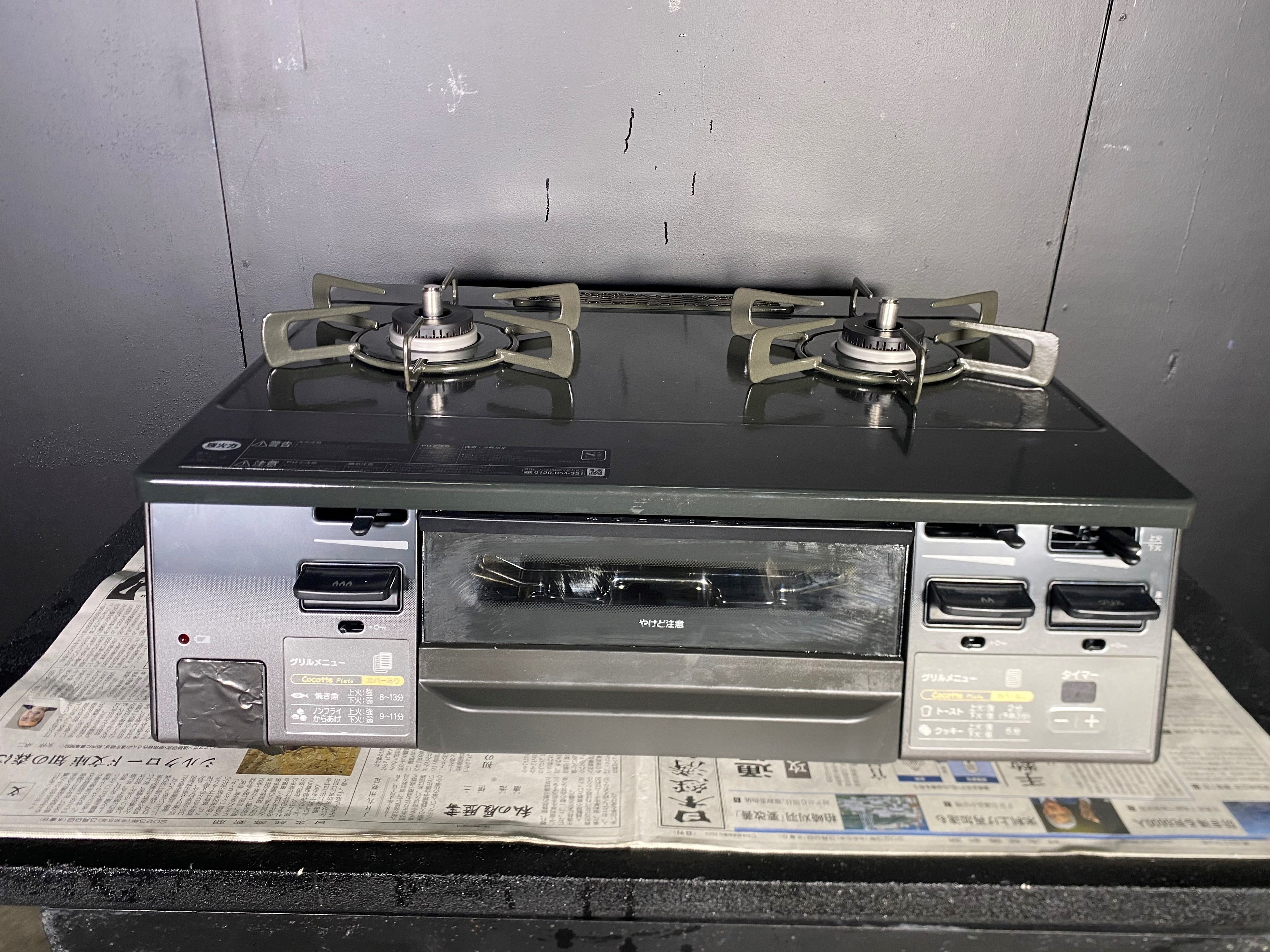 ガスこんろの下に新聞紙を敷く様子