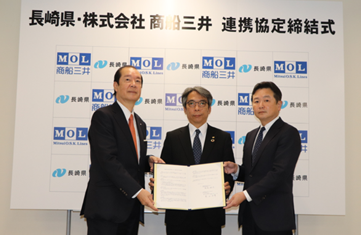 連携協定の締結式を行う長崎県　松尾産業労働部長（中央）と澤山グループ　澤山精一郎代表 （左側）と当社電力・風力エネルギー事業群 杉山第二ユニット長（右側） ※撮影時のみマスクを外しています