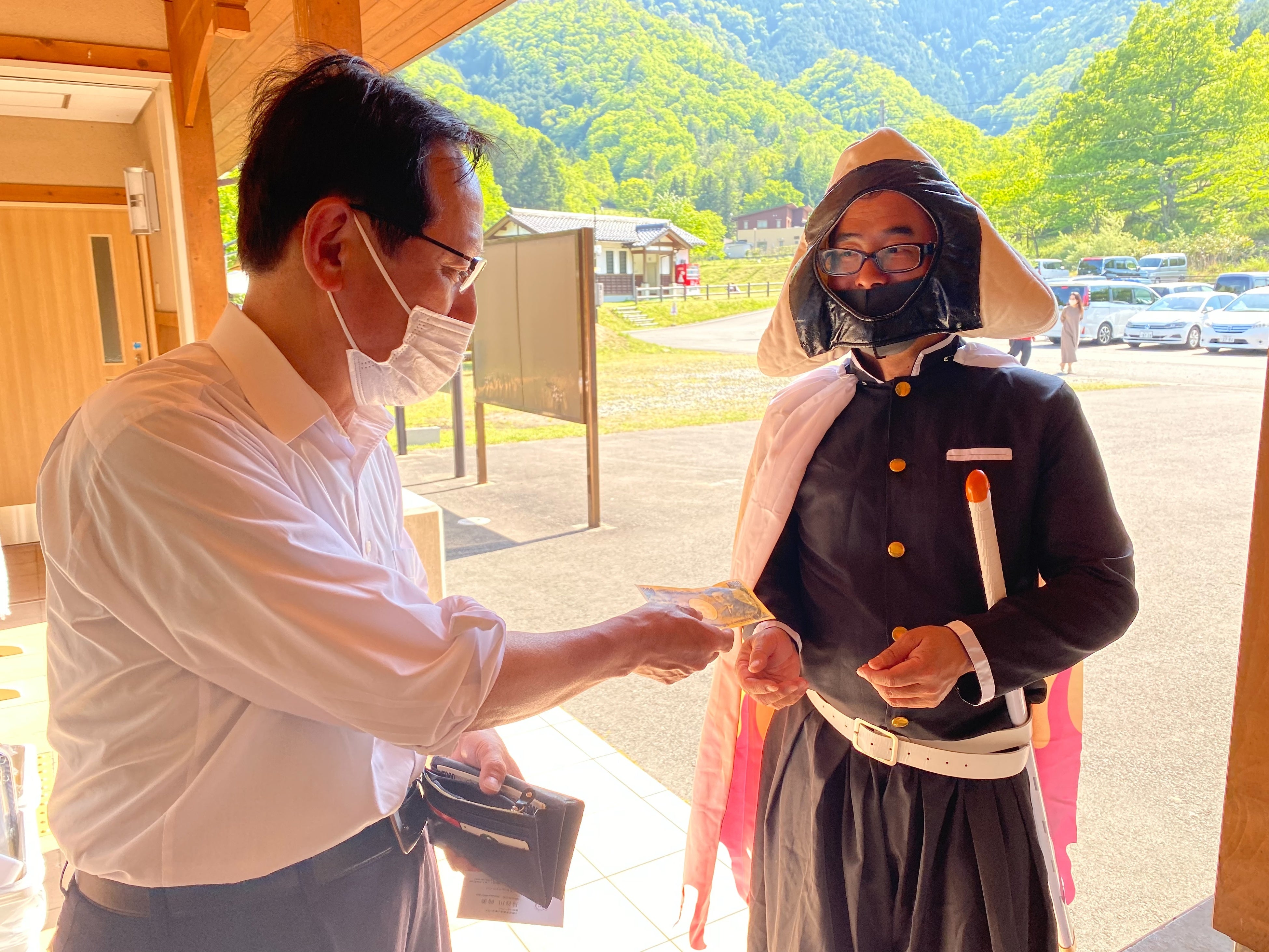 写真左　養父市議会議員　深沢巧様　はさまじフォレストのイベントに現れた鍵庄の広報担当おにぎりさんから明石海苔を購入している様子（５月４日）