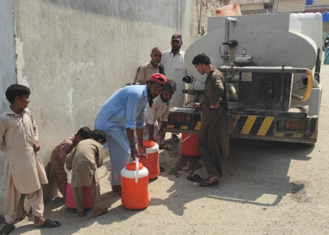 AARが手配した給水車から水をくむ住民
