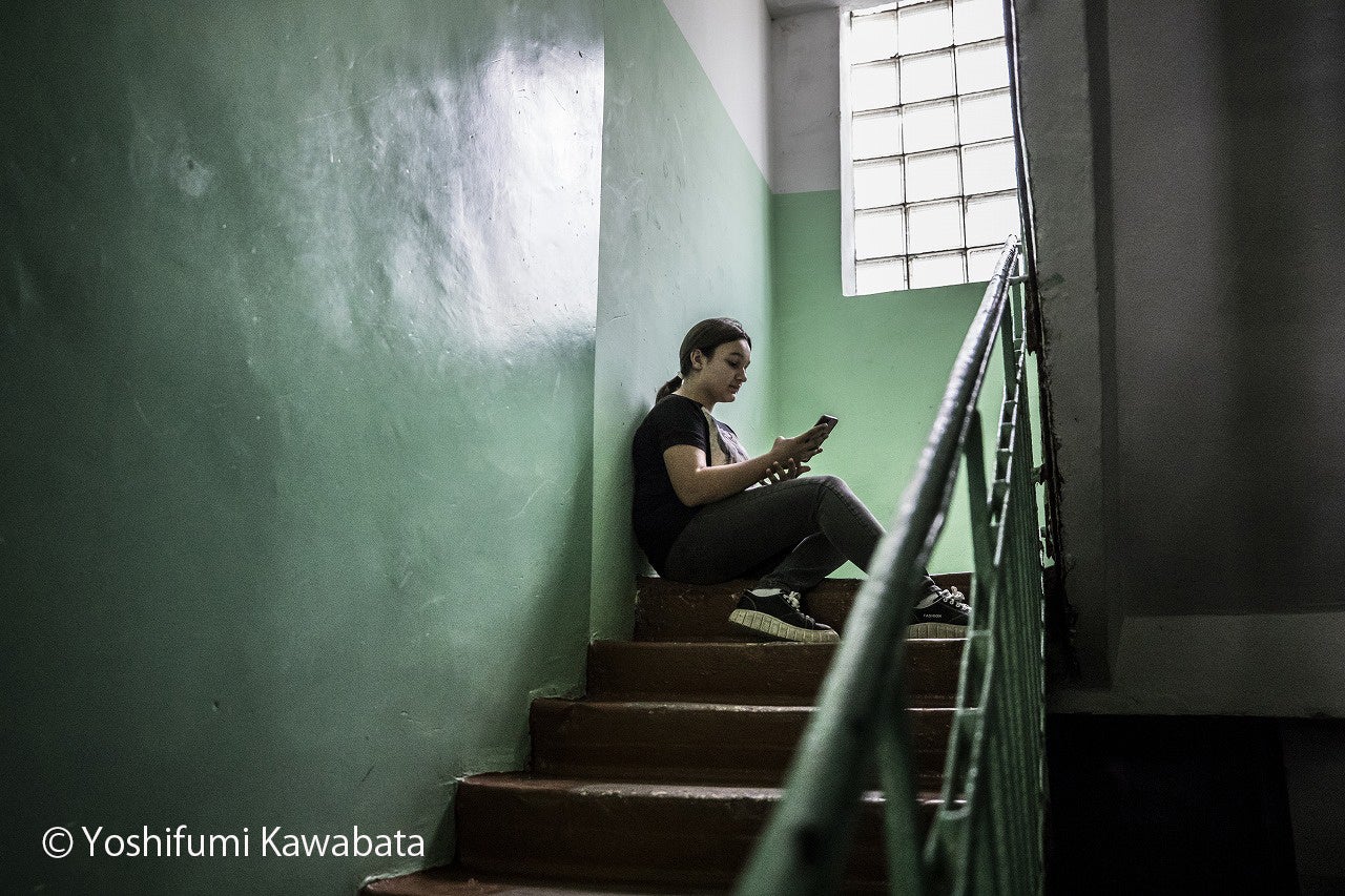 隣国モルドバの大学学生寮で避難生活を送るウクライナ難民の女の子。離れ離れになった故郷の友人とスマートフォンで連絡をとっていた（2022年5月、川畑嘉文撮影）