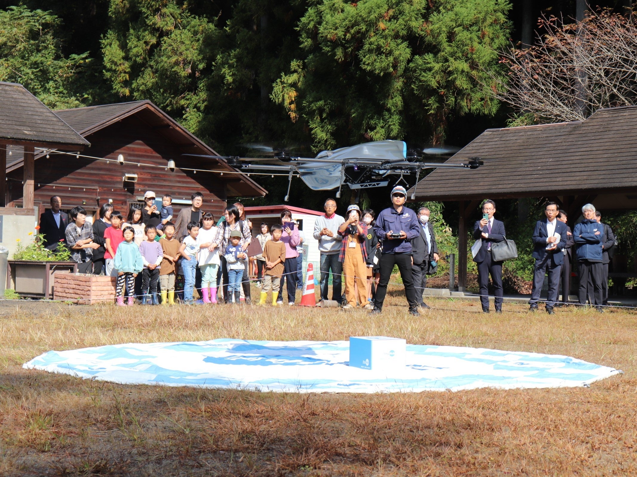 ドローン配送されたお菓子を受け取る子供たち （RECAMP足利）