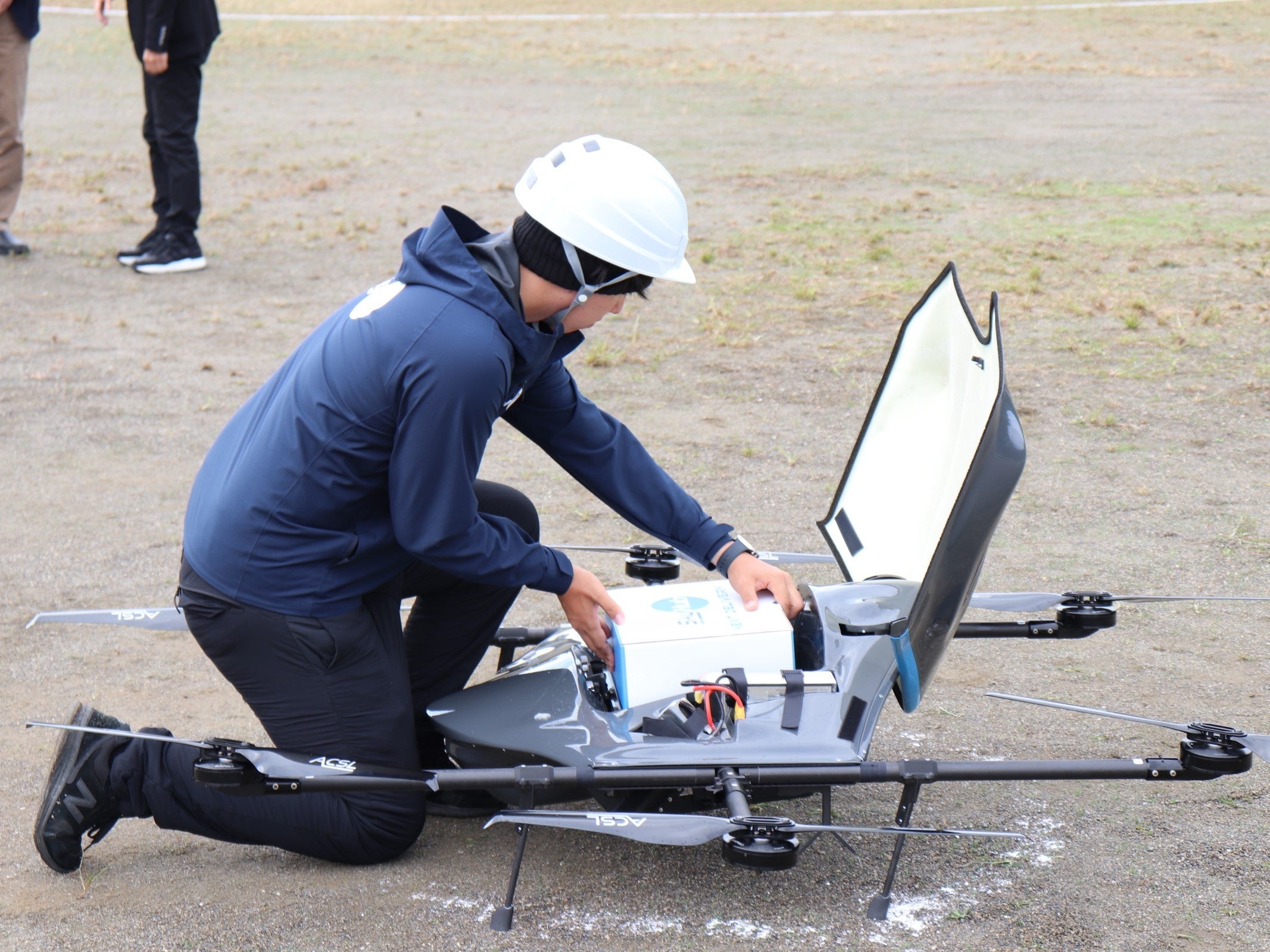 物流専用ドローンAirTruckに箱をセットするスタッフ