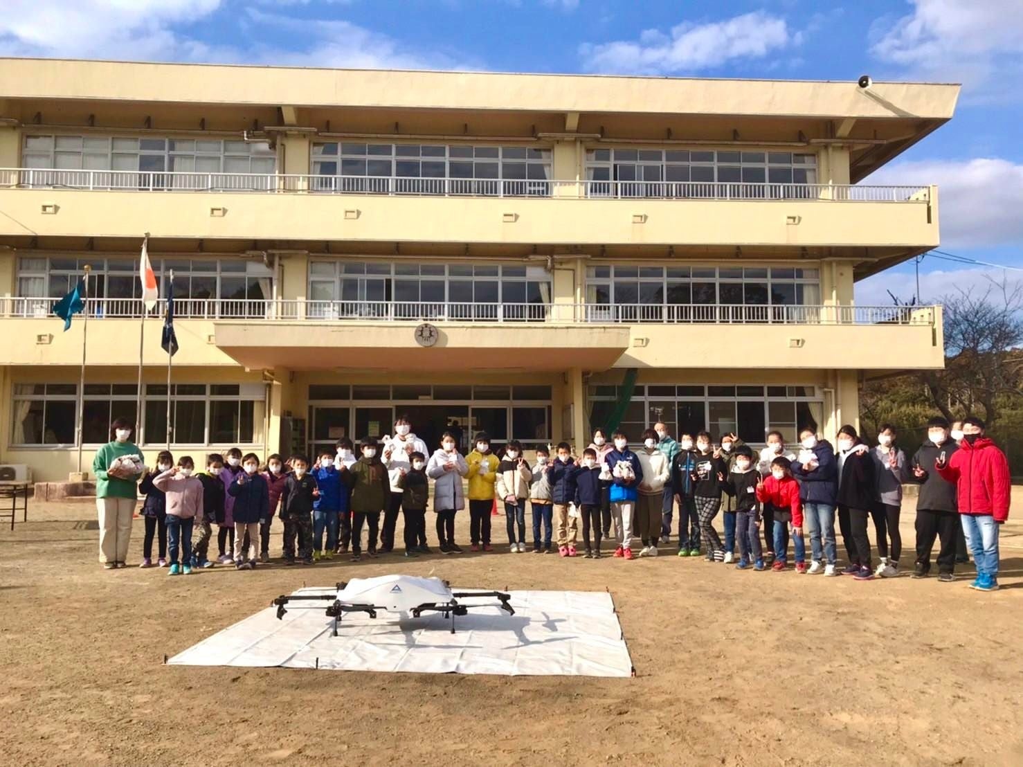 小学校の生徒たちへバレンタインチョコレートを届けたドローンと記念撮影 （豊浜小学校）
