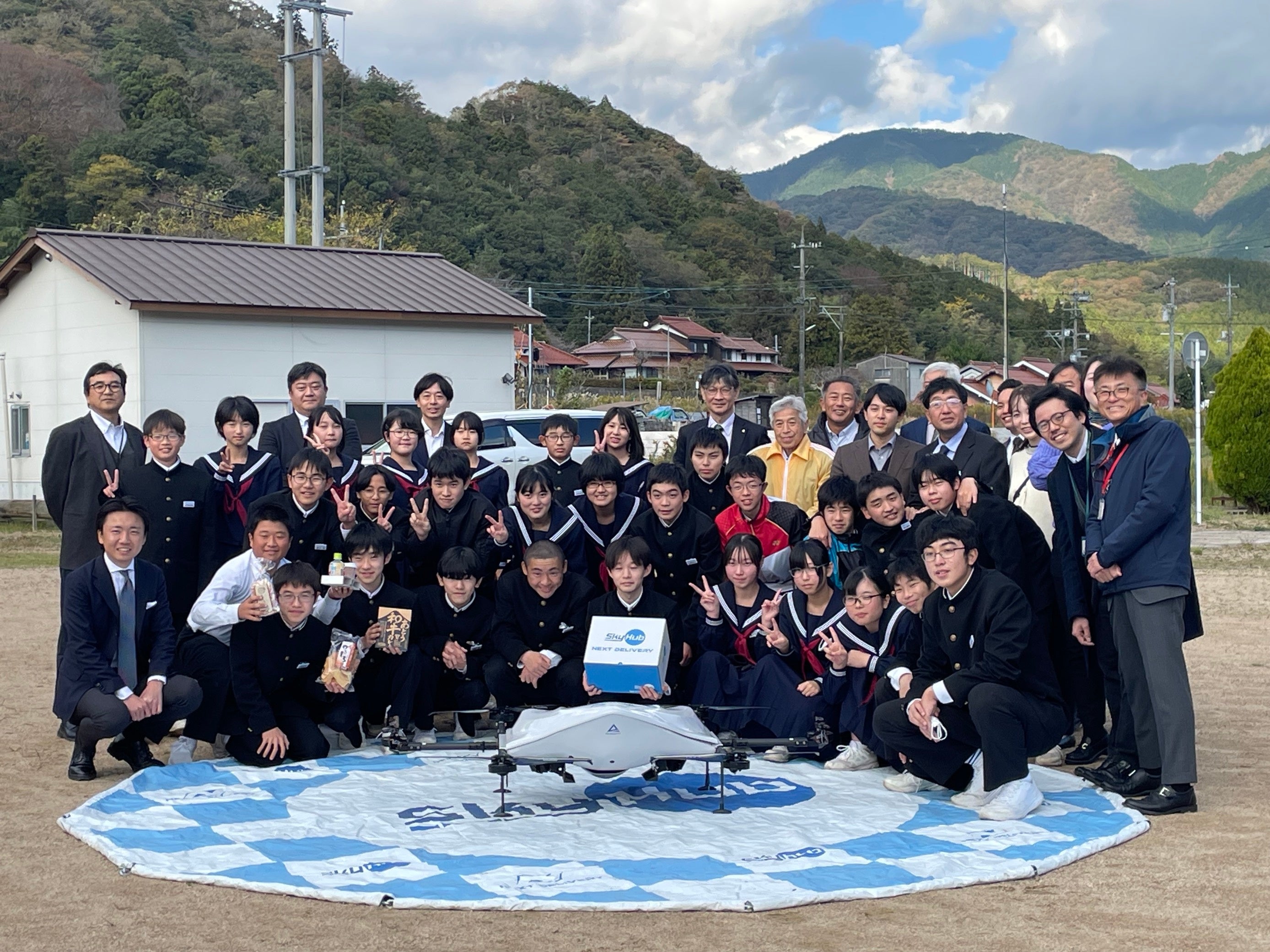 日本発物流専用ドローン“AirTruck”で配送された商品を受け取った阿東中学校の生徒と記念撮影 （三谷ふれあいセンター）