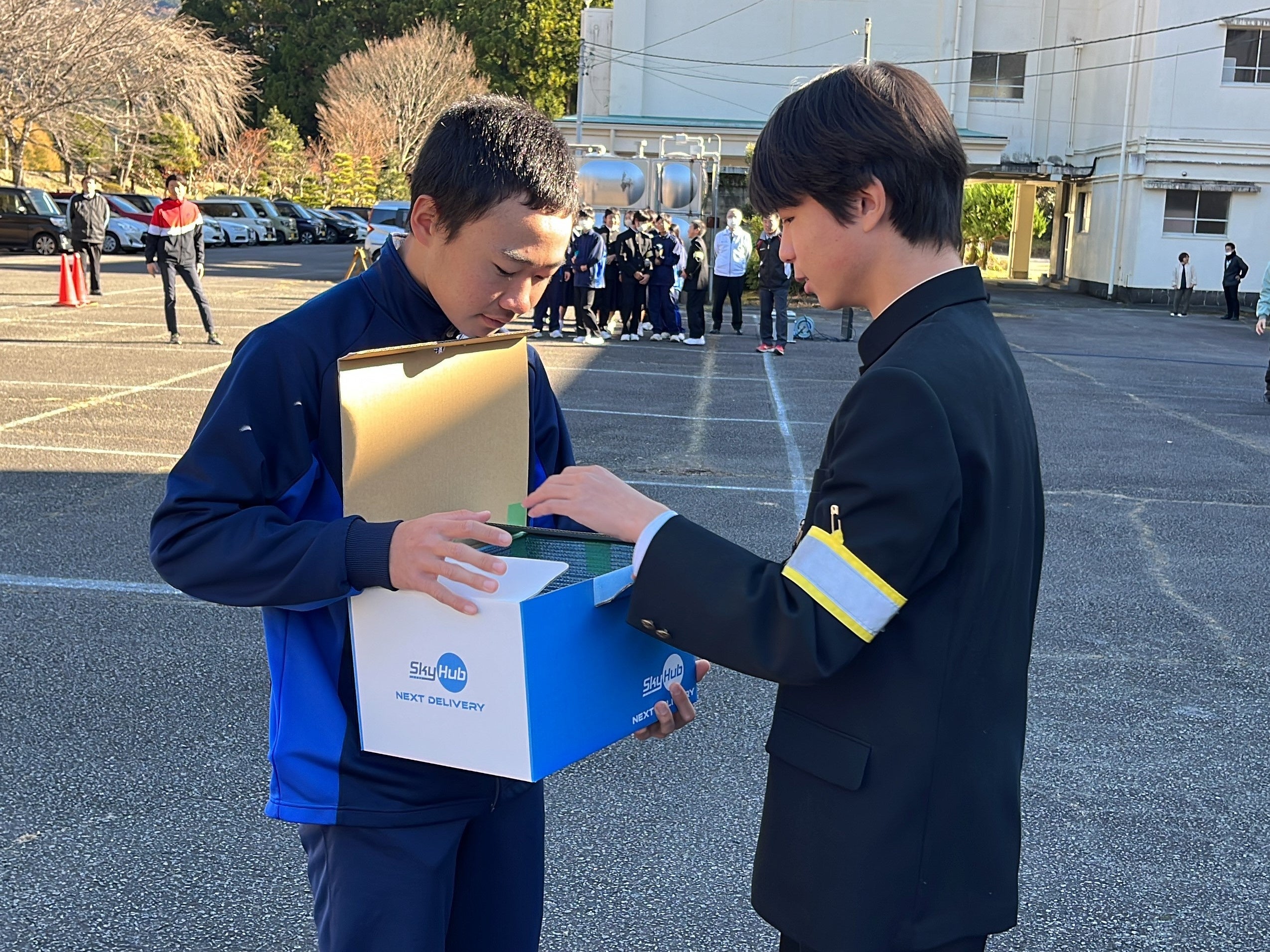 ドローン配送された肉まんとあんまんを受け取る川根中学校の生徒たち （本川根中学校グラウンド）