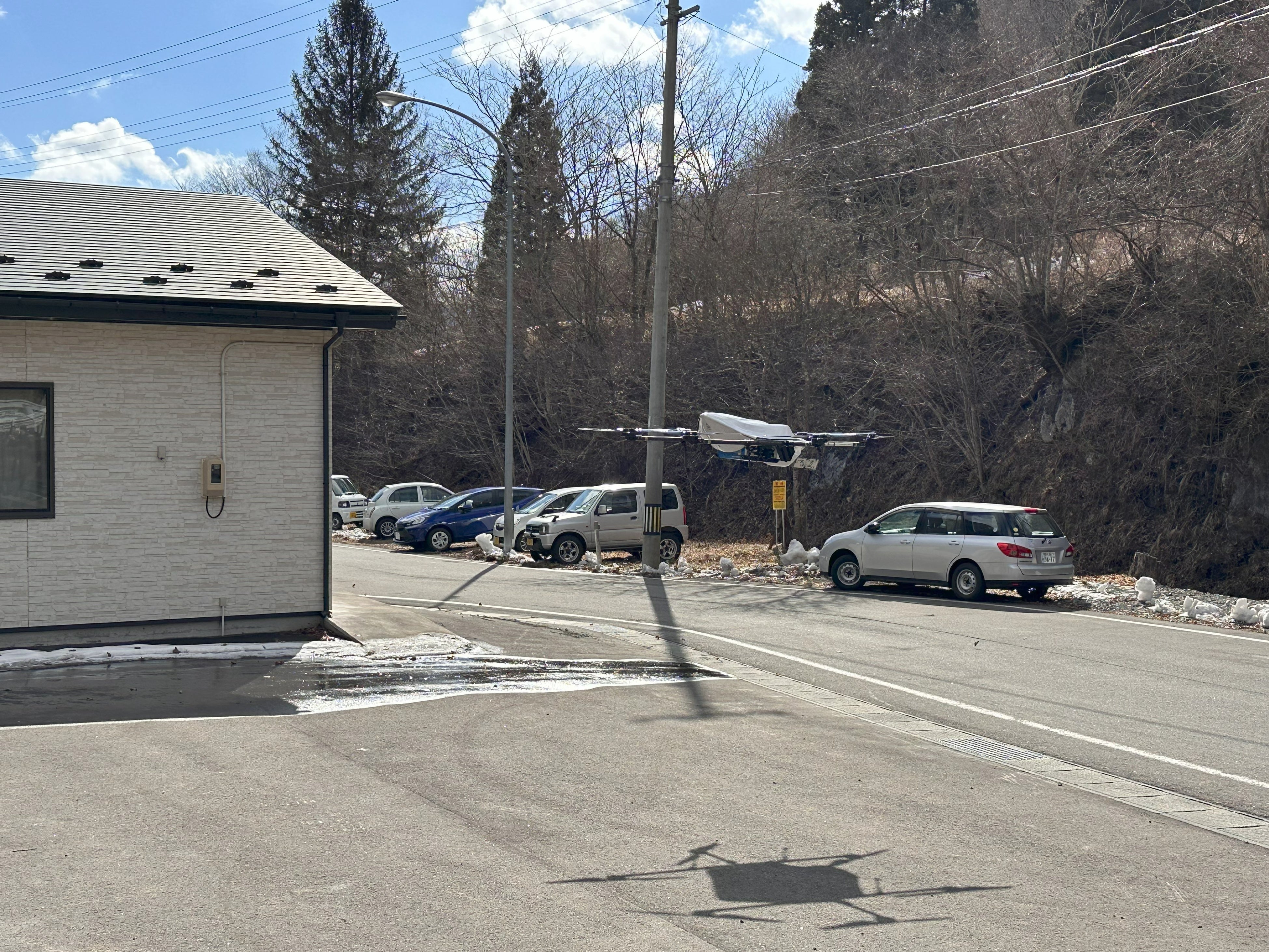 お菓子とドリンクを搭載して着陸する物流専用ドローン”AirTruck” （救沢公民館）