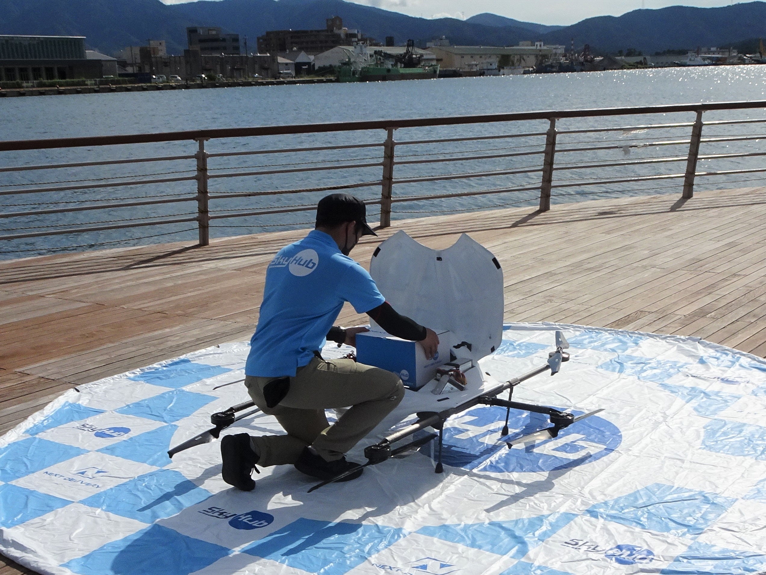 テイクアウト商品が入った箱をドローンにセット（金ケ崎緑地ボードデッキ）