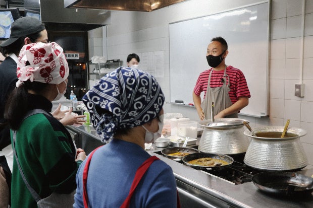 参加者とともにベンガル料理をつくる石濱さん