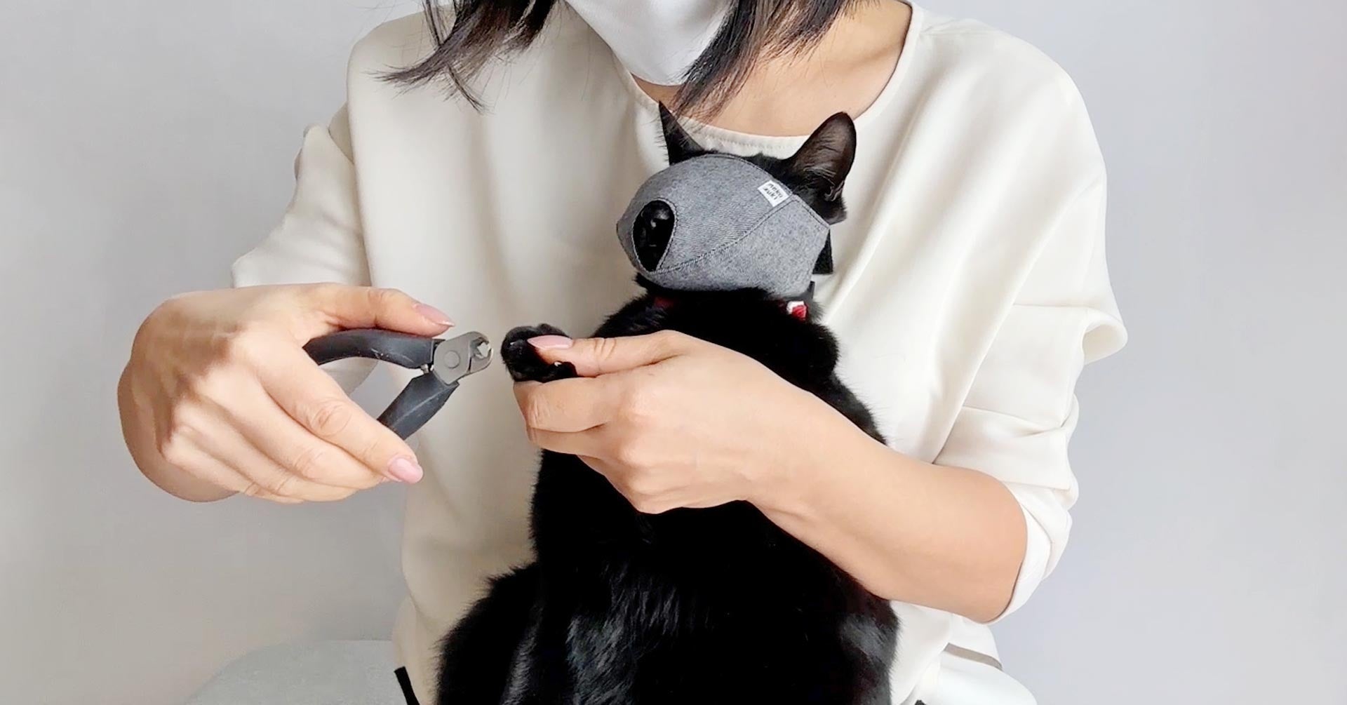 もふもふマスクで爪きり中のネコ