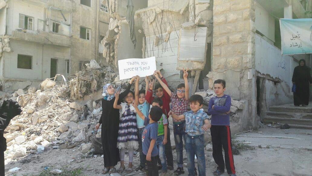 活動直前、破壊された学校の前で撮られた写真（2016年）