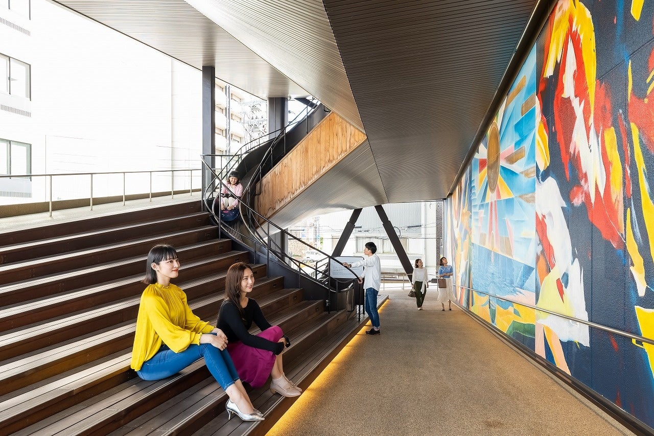 ▴おりづるタワー東側 スパイラルスロープ ＂散歩坂＂にある 約４×２４ｍの巨大壁画。（画像）１層目 三浦恒祺氏「光に向かって這っていけ」