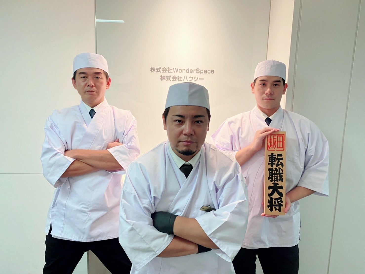 会社のロゴが隠れないよう中腰になる転職大将。