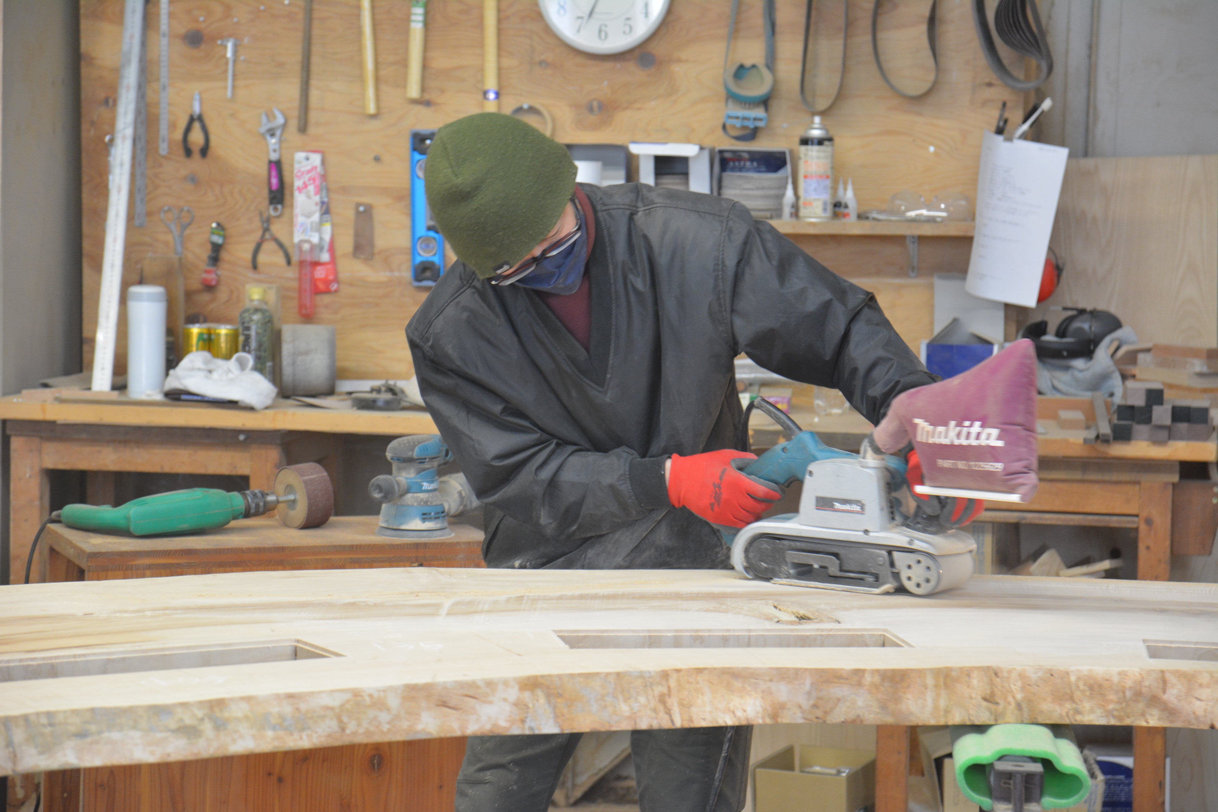 職人が手作業で天板表面を磨く様子