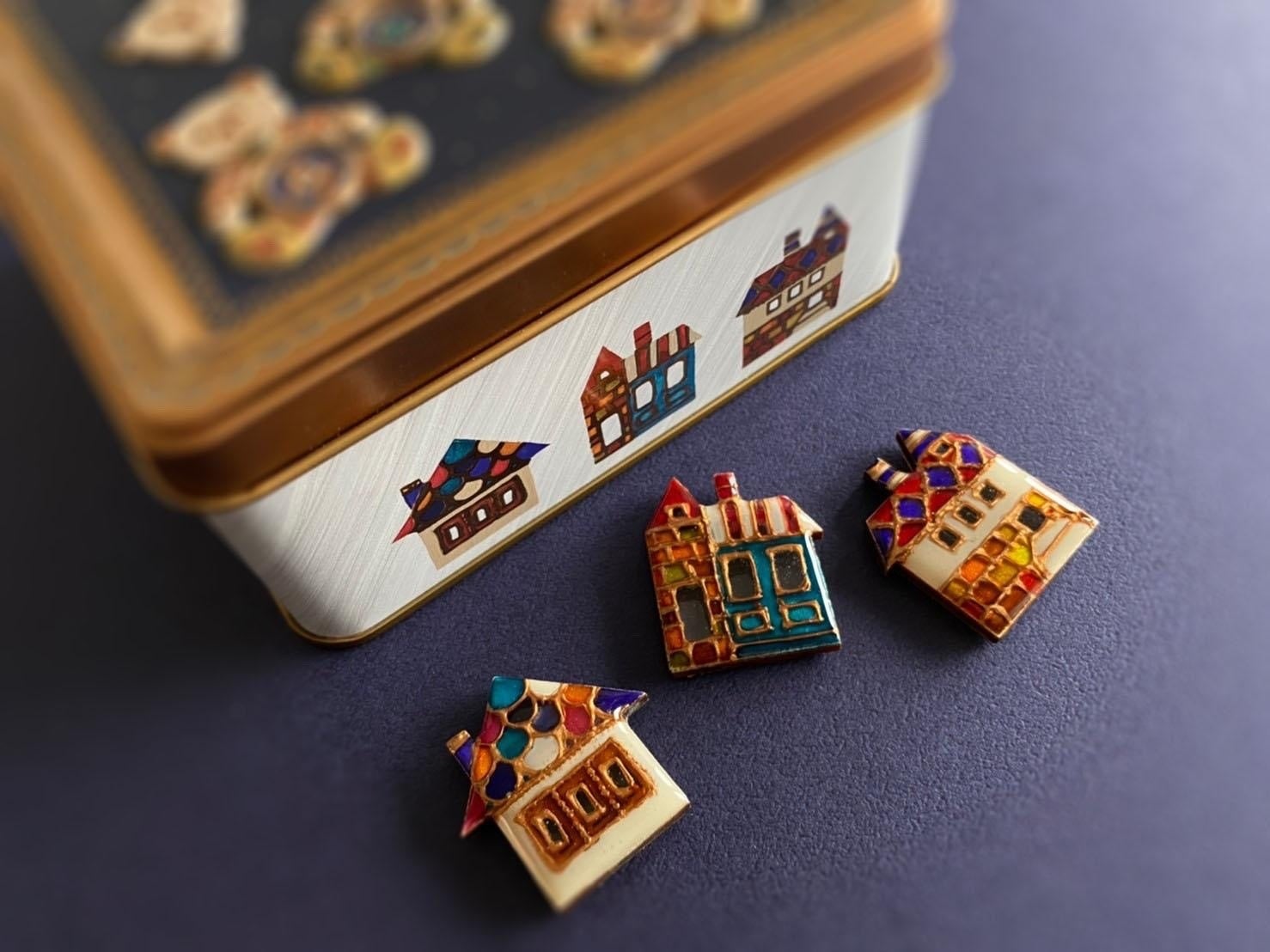 缶の側面に描かれた「世界の街並みブローチ」