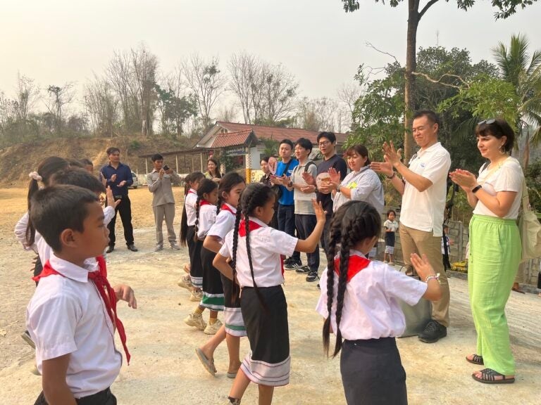 登校の時間にあわせ訪問した大塚倉庫の皆さんを、花飾りと子ども達の踊りで歓迎してくれました。