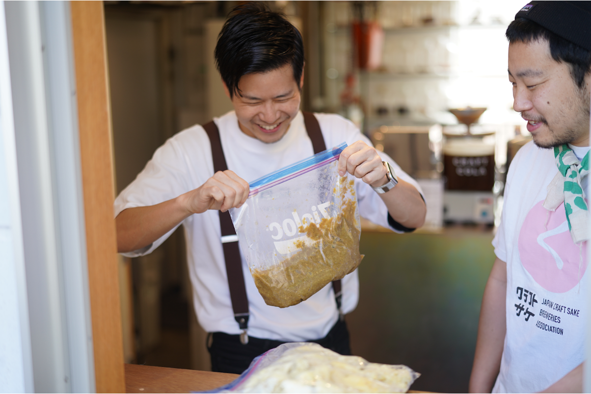 【写真】実験用のコーラ粕受け渡しの様子