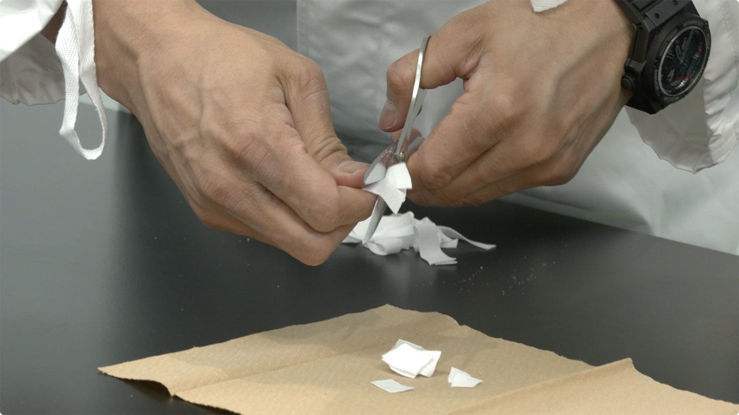 武井さんがPIECLEXのマスクで使われている布をハサミで切る様子