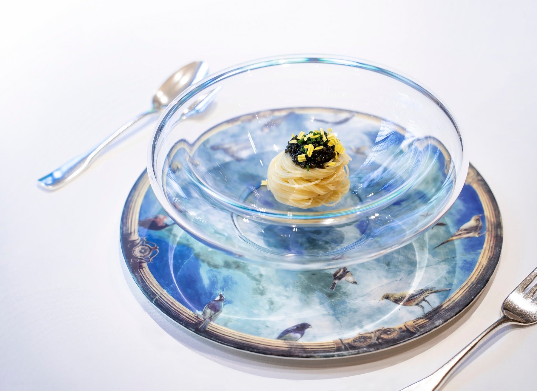絵皿をショープレートにして盛りつけたスペシャリテの「キャビアの冷製カッペリーニ」