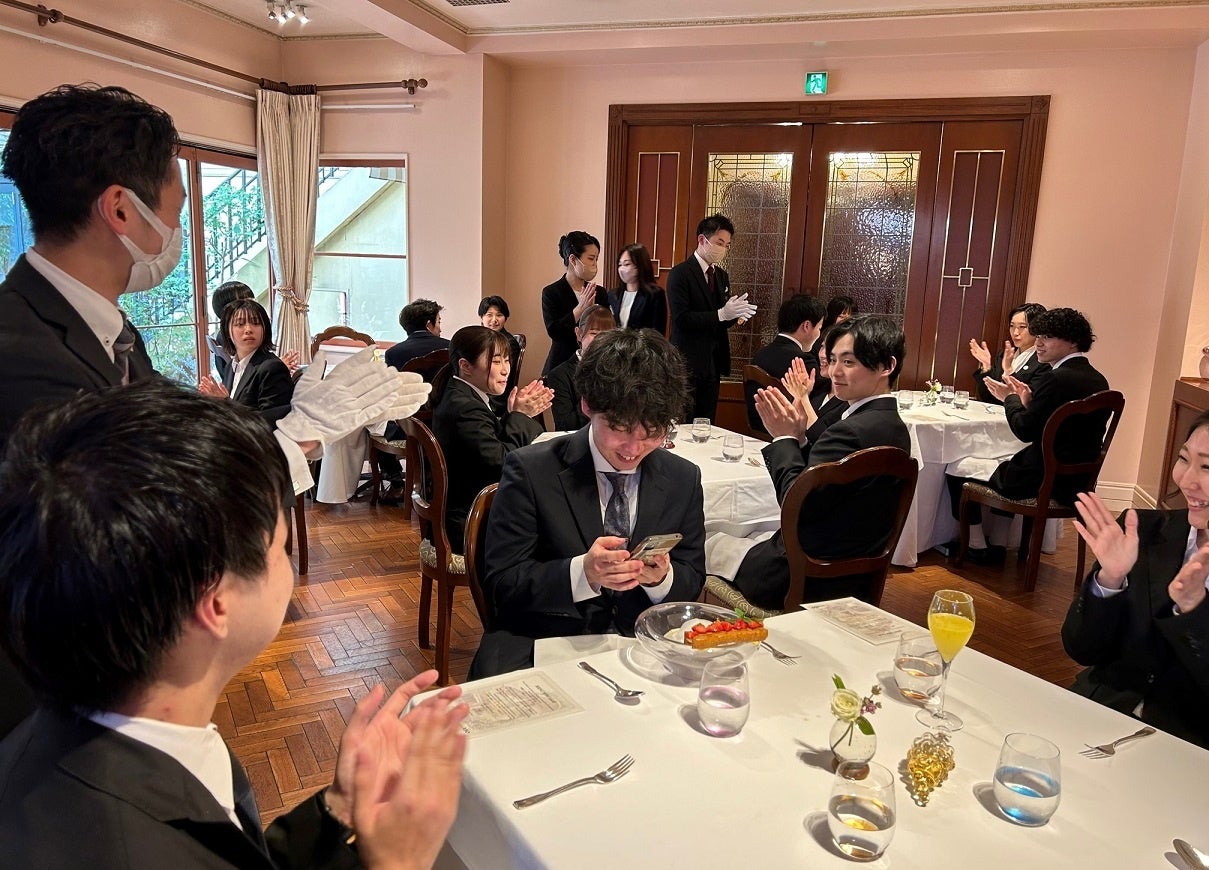 みんなからお祝いの拍手を贈られる新入社員