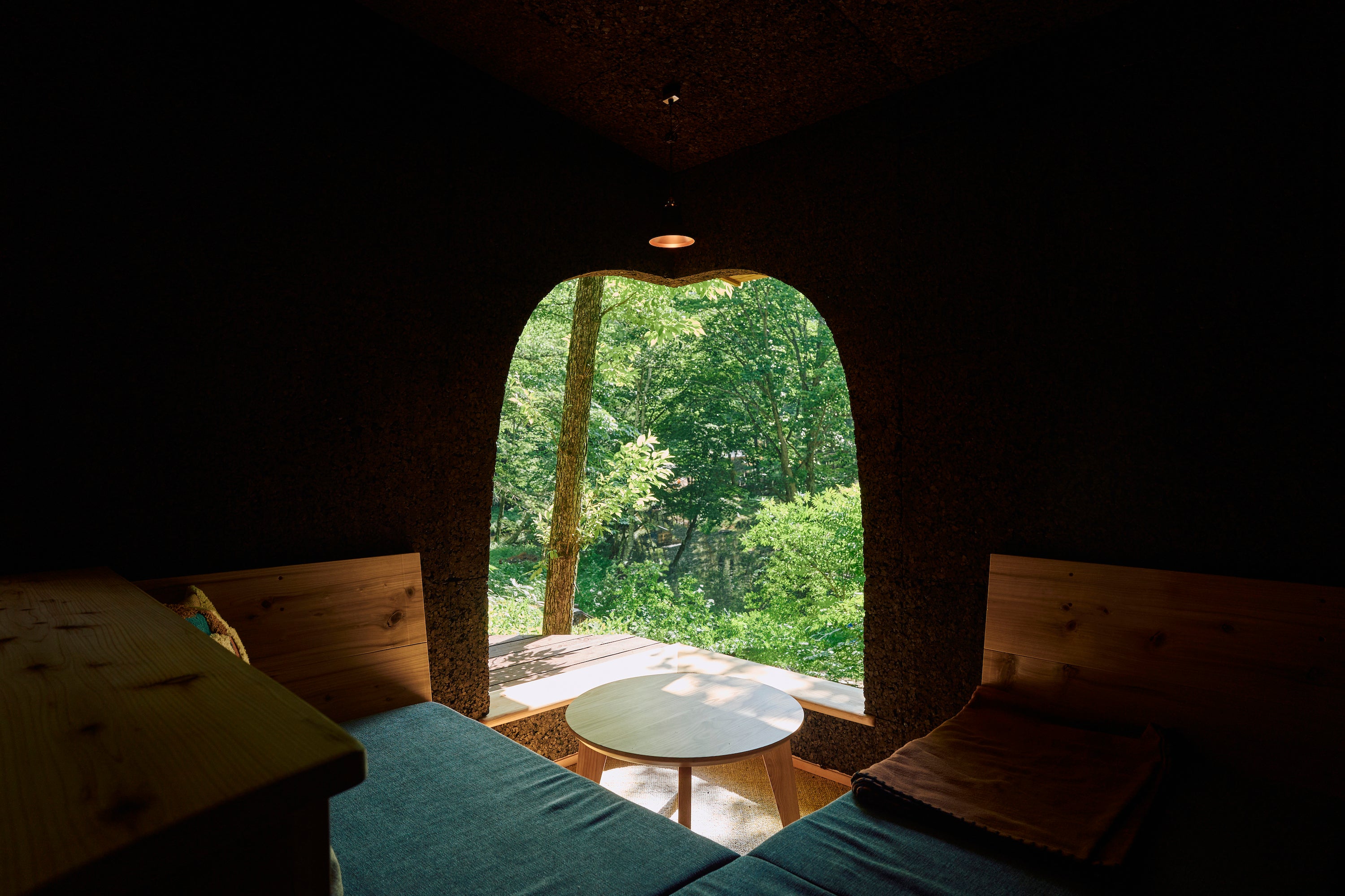 コーナーの柱を取り除いた深い褐色の壁から覗く風景