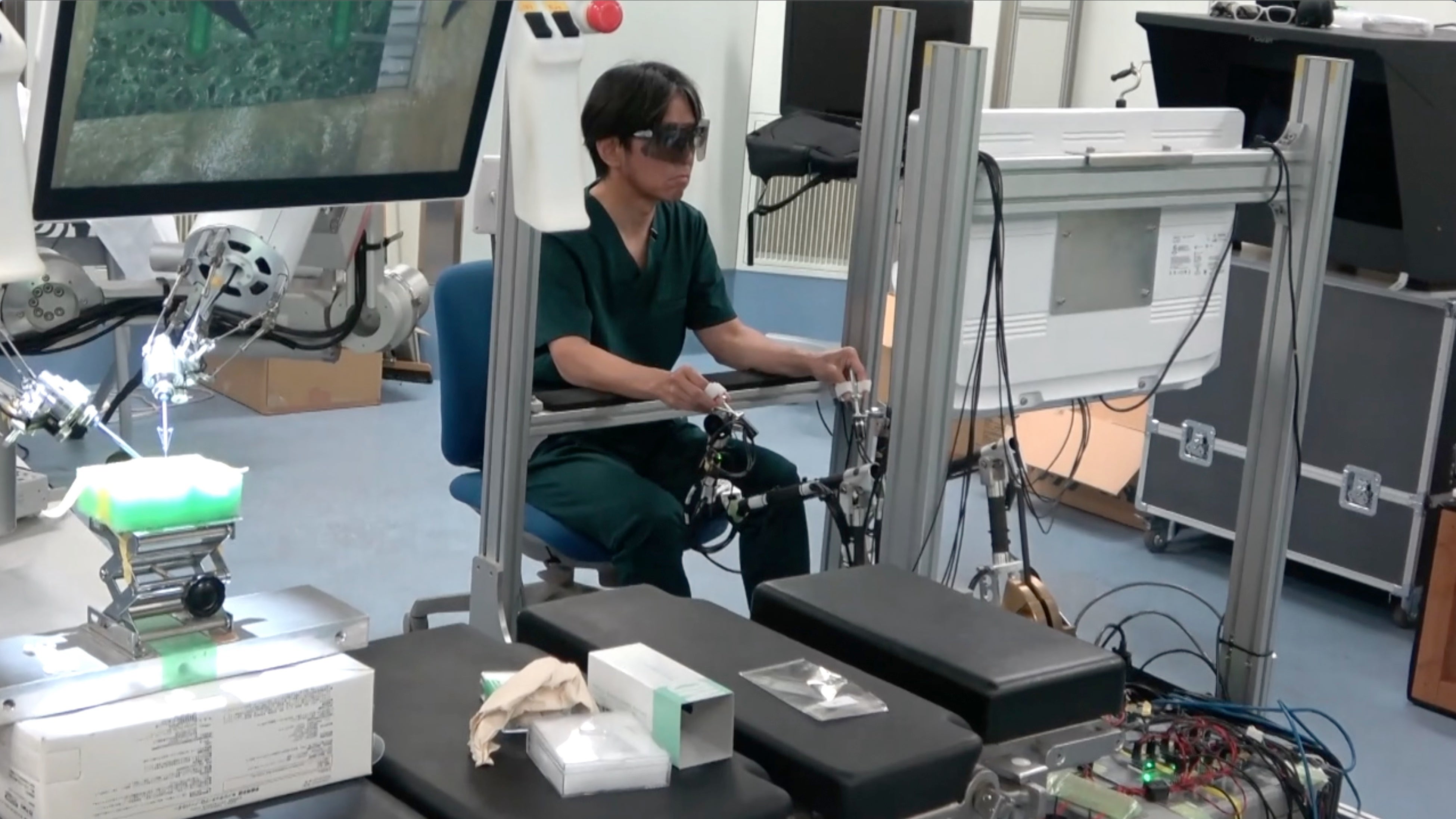 試験の様子。左)マイクロサージャリー支援用ロボットの本体、右)操作用のメインコンソール