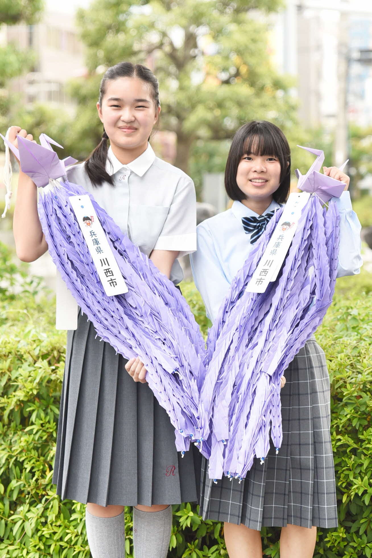 越田市長から折り鶴を託される折り鶴平和大使の２人。小室さん（写真右）、出野さん（写真左）