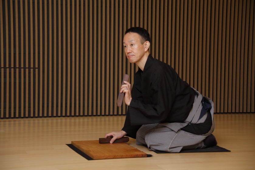 附け打ちの山﨑徹さん。舞台上で芝居に音を付ける役目。附け板に2本の拍子木を打ち付けて、登場人物の仕草や動作を強調します。