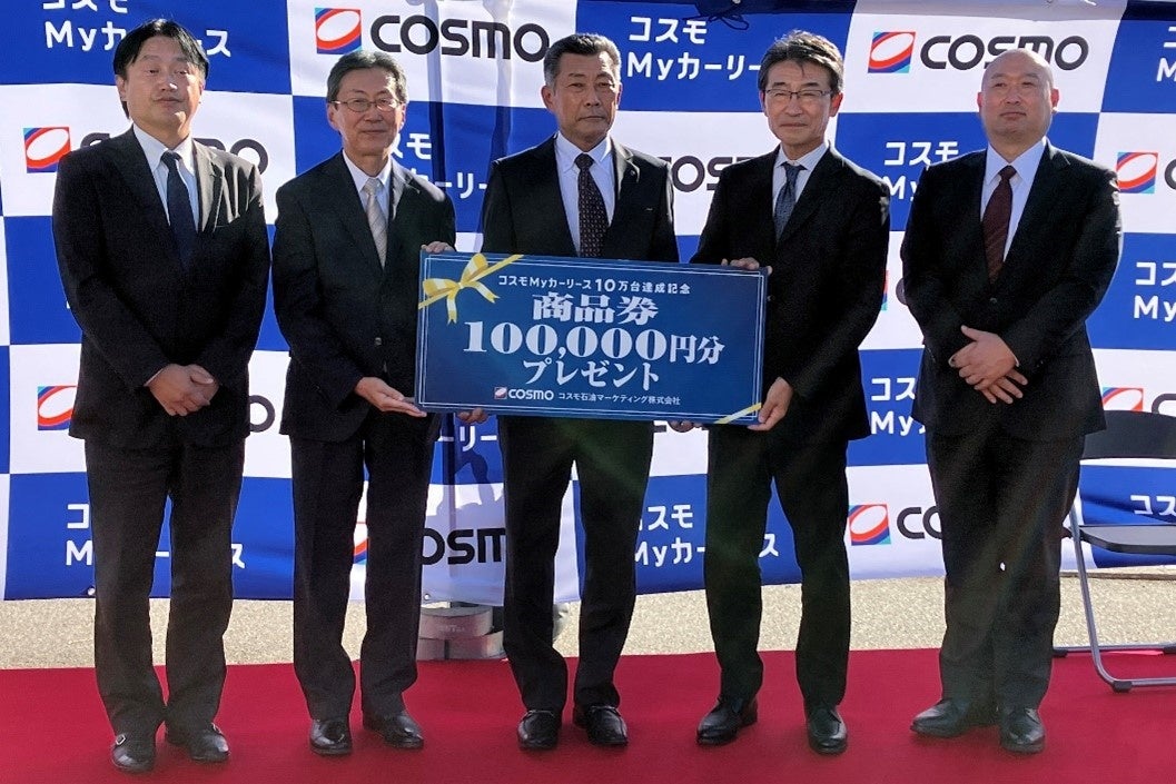 ▲記念品贈呈　（左から、安上支店長、森山社長、10万台目のご契約者の平井様、野村社長、角谷部長）