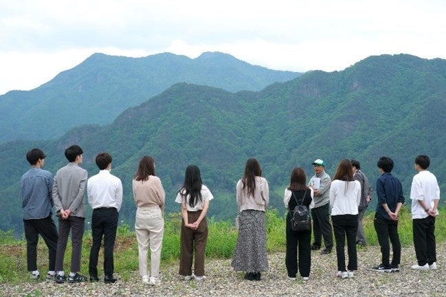 南相木村の自然の中で村の職員と話す様子
