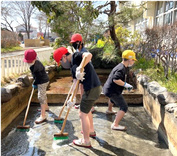 池の掃除をする児童