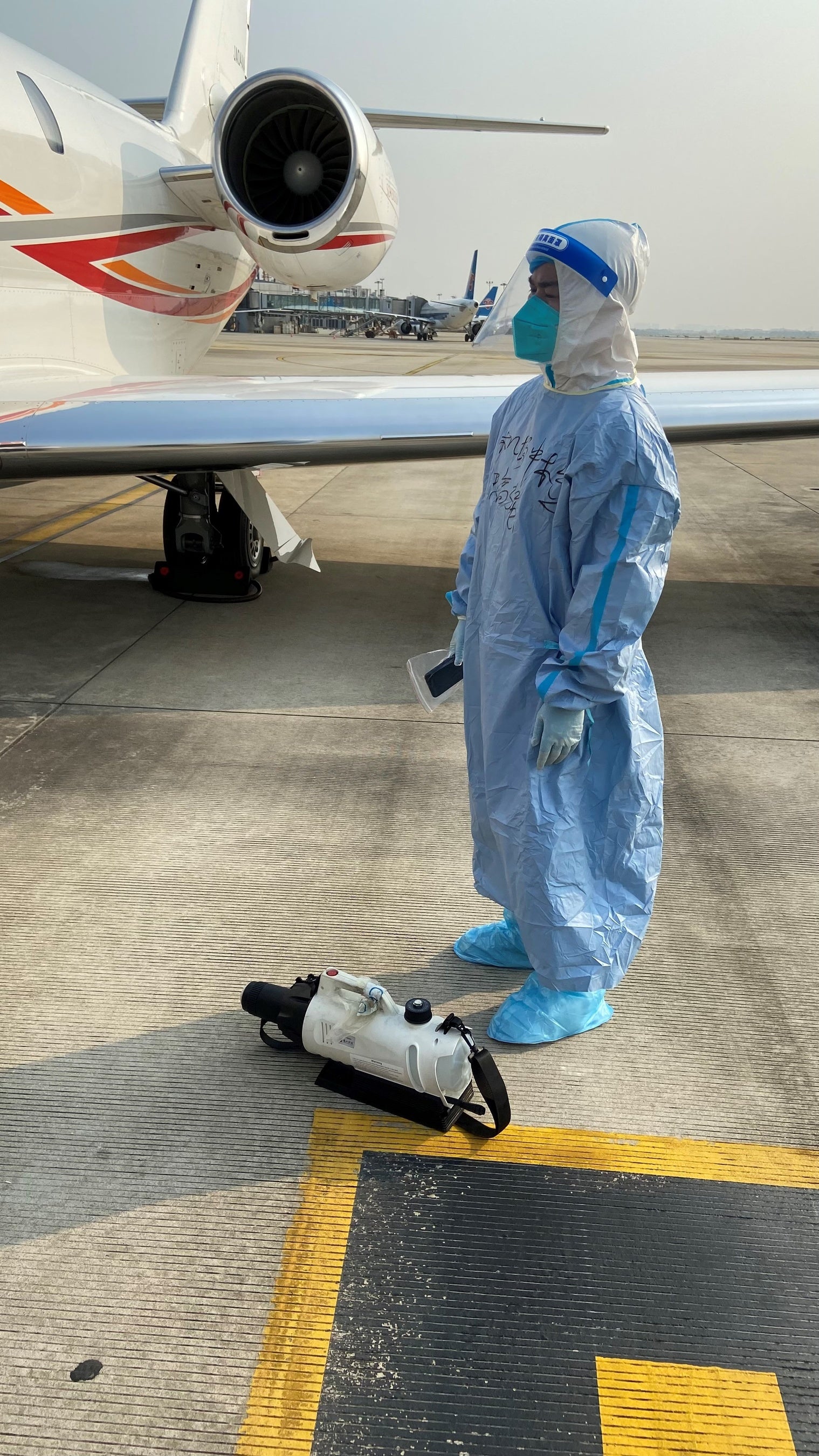 写真4：完全防護服のスタッフ（中国駐機場）