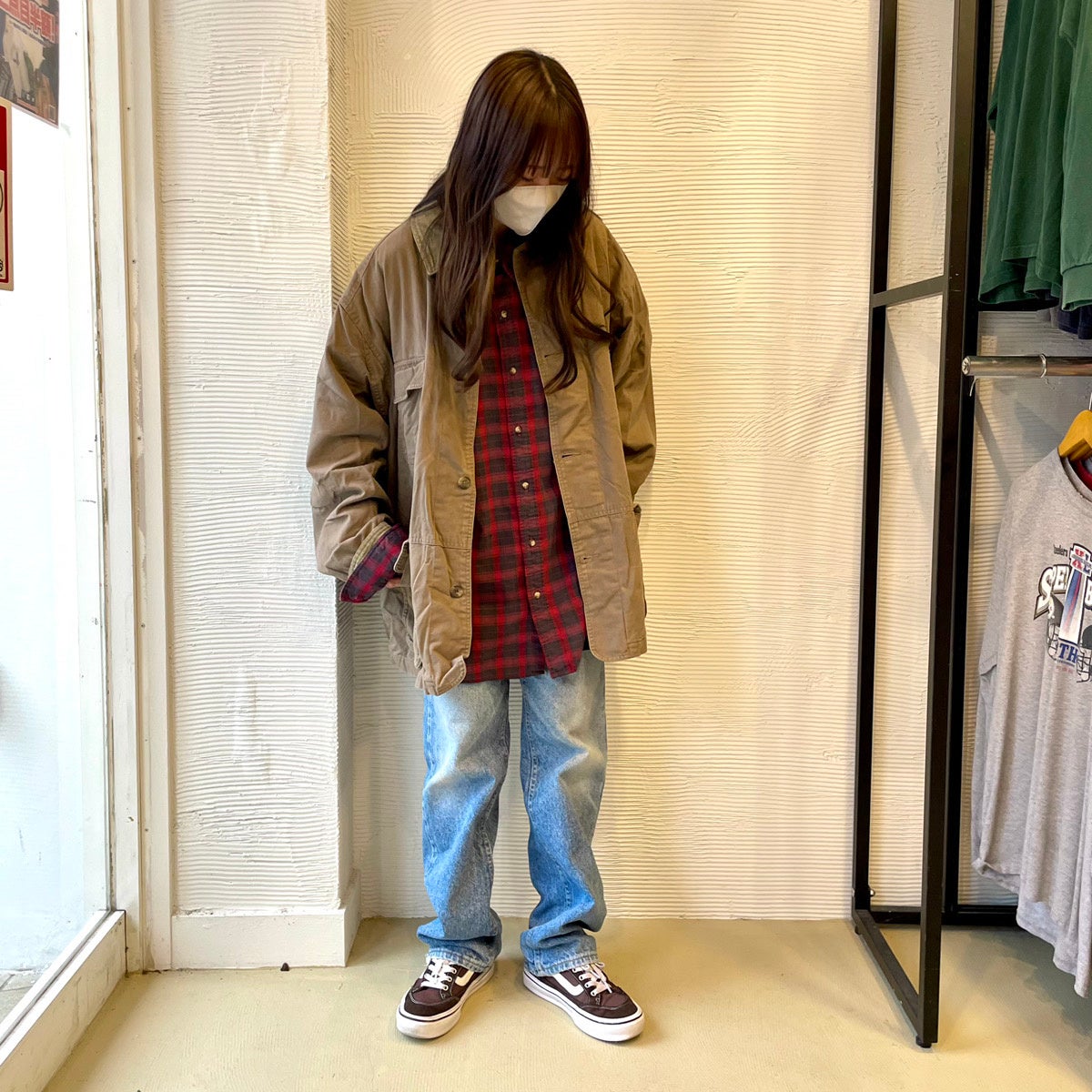 カバーオールにデニムを合わせたシンプルコーデ。赤色シャツがポイント