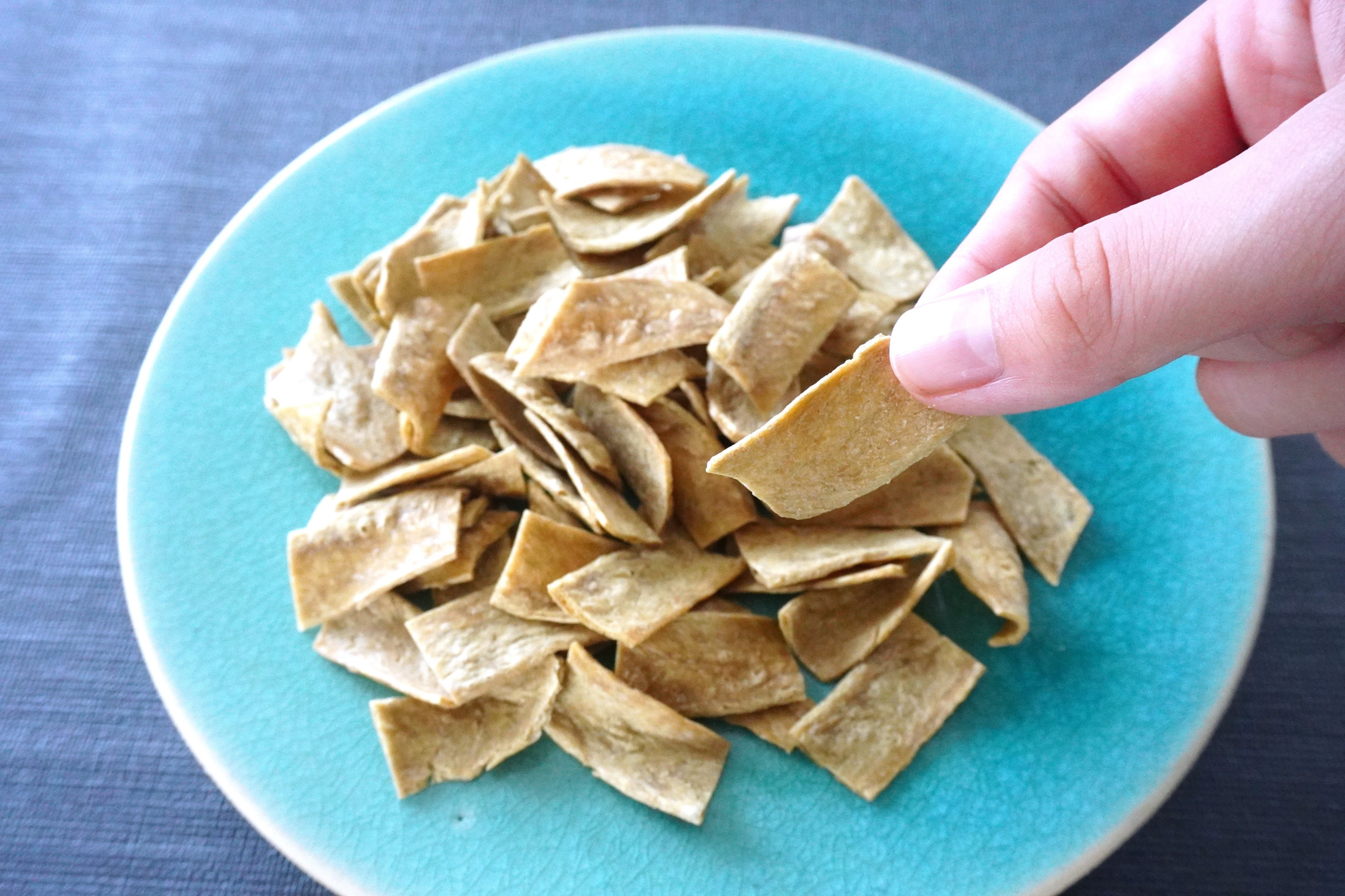 月桃大豆チップスは、ほのかにグリーンがかった仕上がりに。塩だけのシンプルな味付けで。